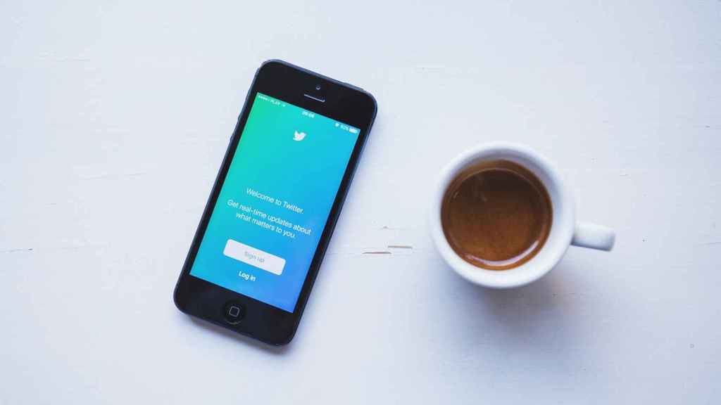 App de Twitter junto a una taza de café.
