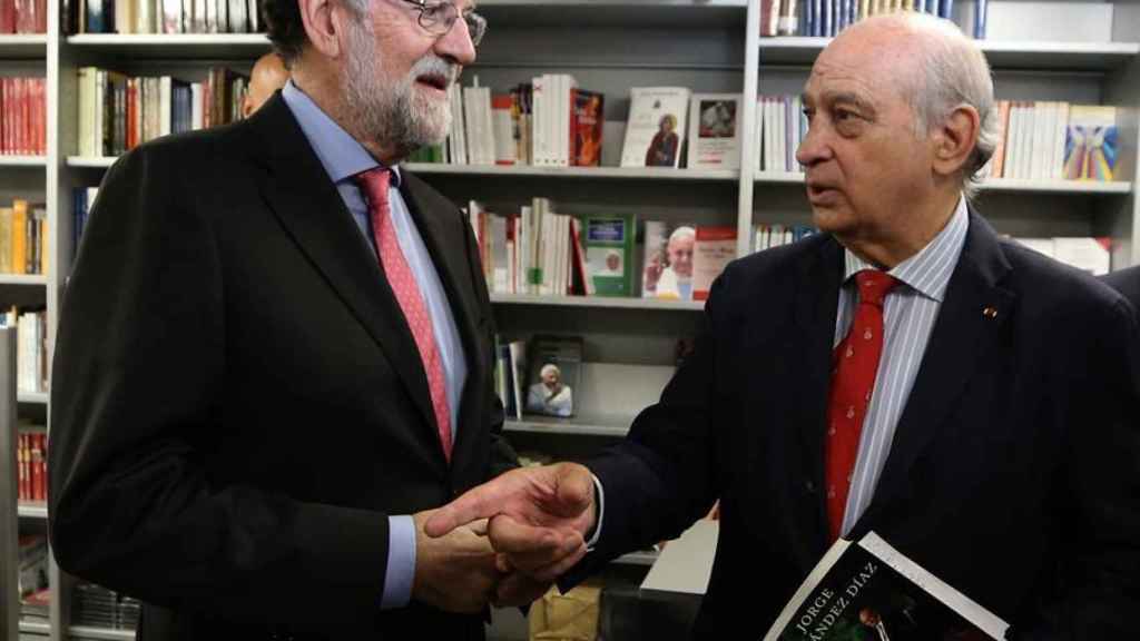 El expresidente del Gobierno Mariano Rajoy conversa con el exministro del Interior Jorge Fernández Díaz durante la presentación de su libro.