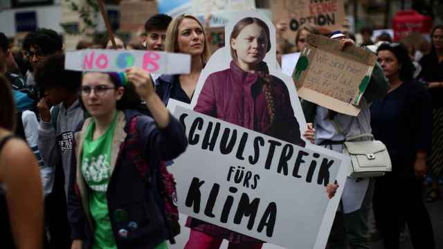 Una joven con un recorte de Greta Thunber en la huelga mundial por el clima en Viena.