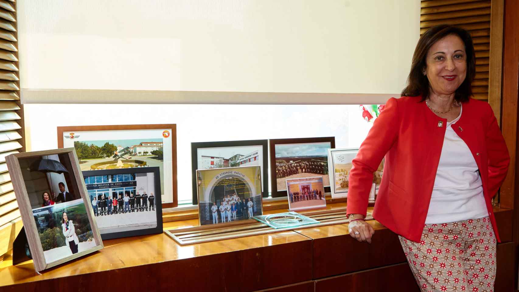 Margarita Robles, en su despacho, junto a varias fotografías en visitas a misiones internacionales.