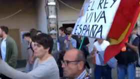 Un hombre lleva una bandera de España a una protesta estudiantil