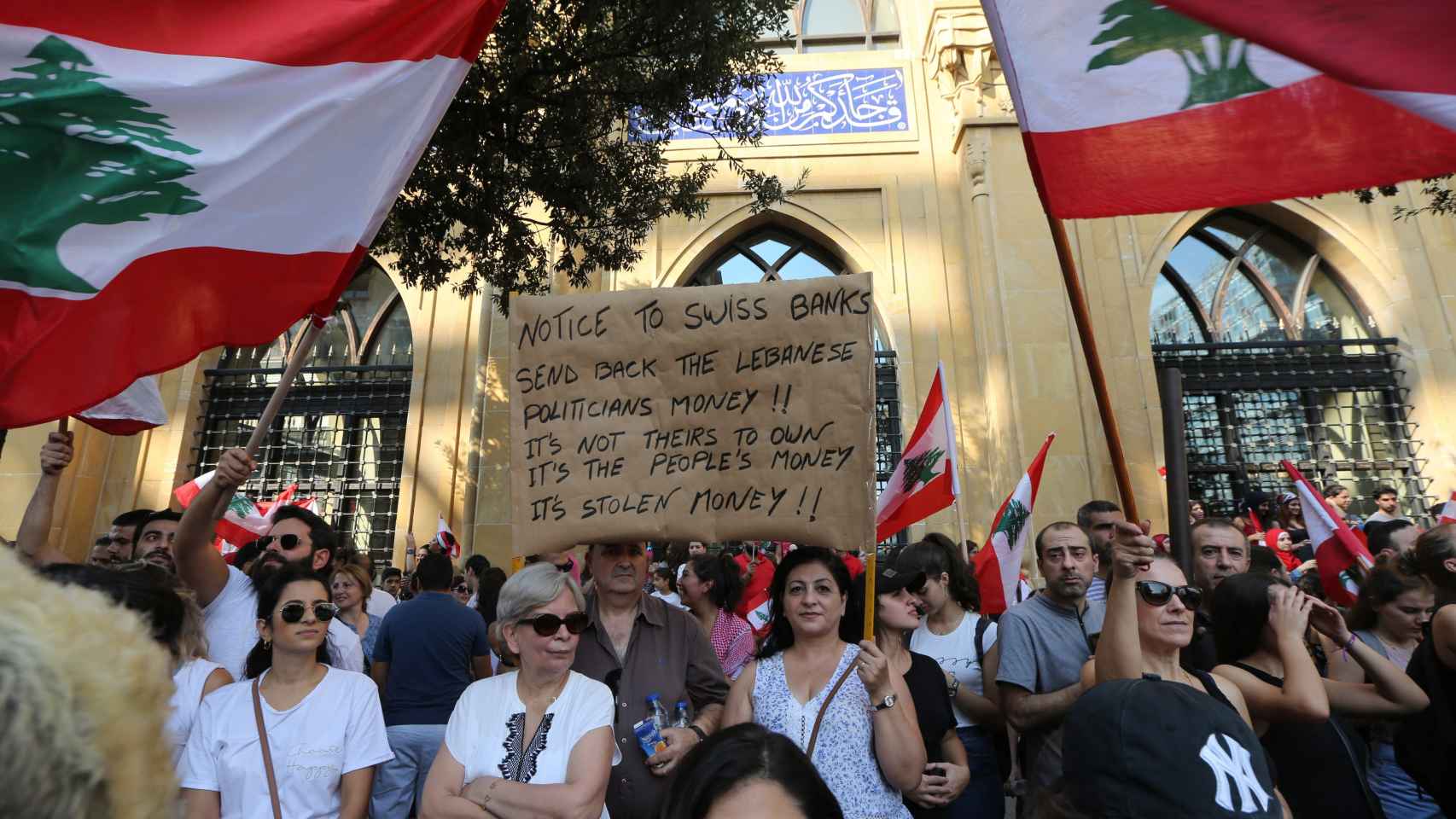 Una manifestante porta un cartel en el que denuncia la corrupción con el mensaje: Aviso a los bancos suizos: devuelvan el dinero de los políticos libaneses. No es suyo, es el dinero de la gente. Es dinero robado.