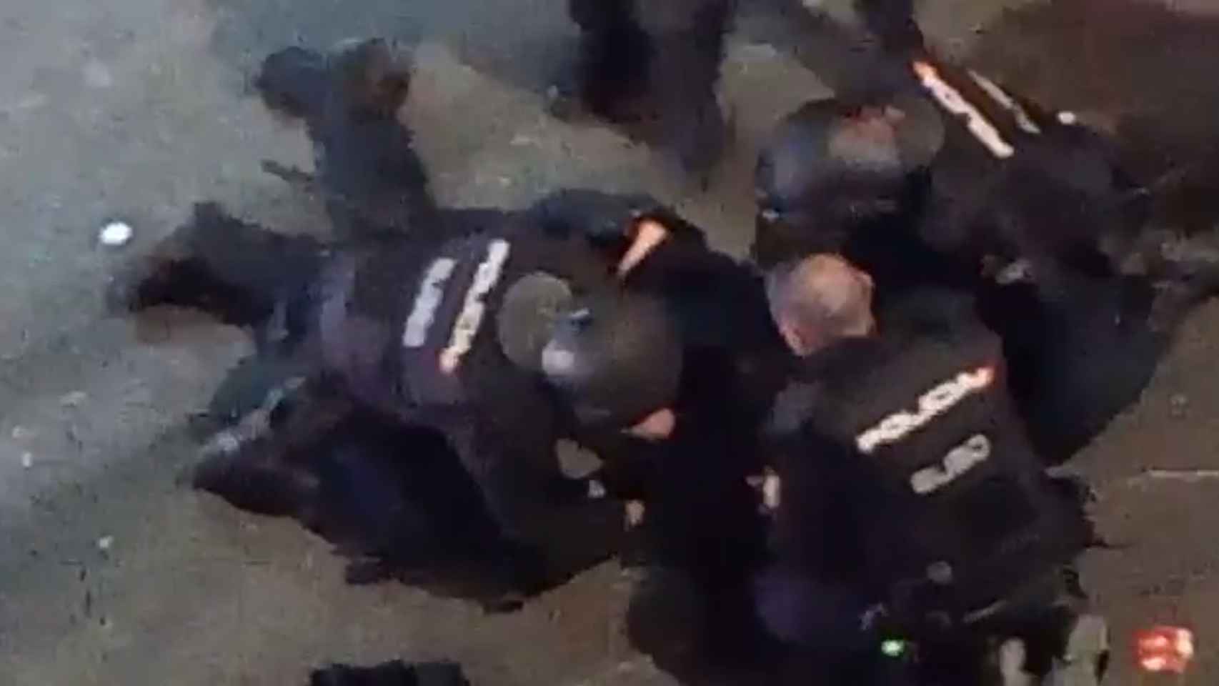 Iván, el policía herido, tendido en el suelo mientras sus compañeros le atienden.
