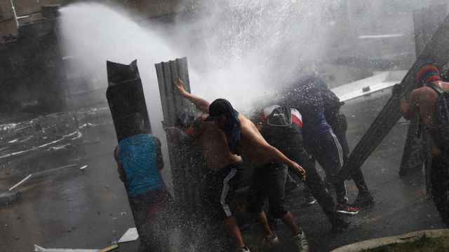 Manifestantes contra un cañón de agua de la Policía en Santiago de Chile