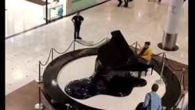 La mujer comenzó a tocar el piano bajo la atenta mirada de varios clientes.