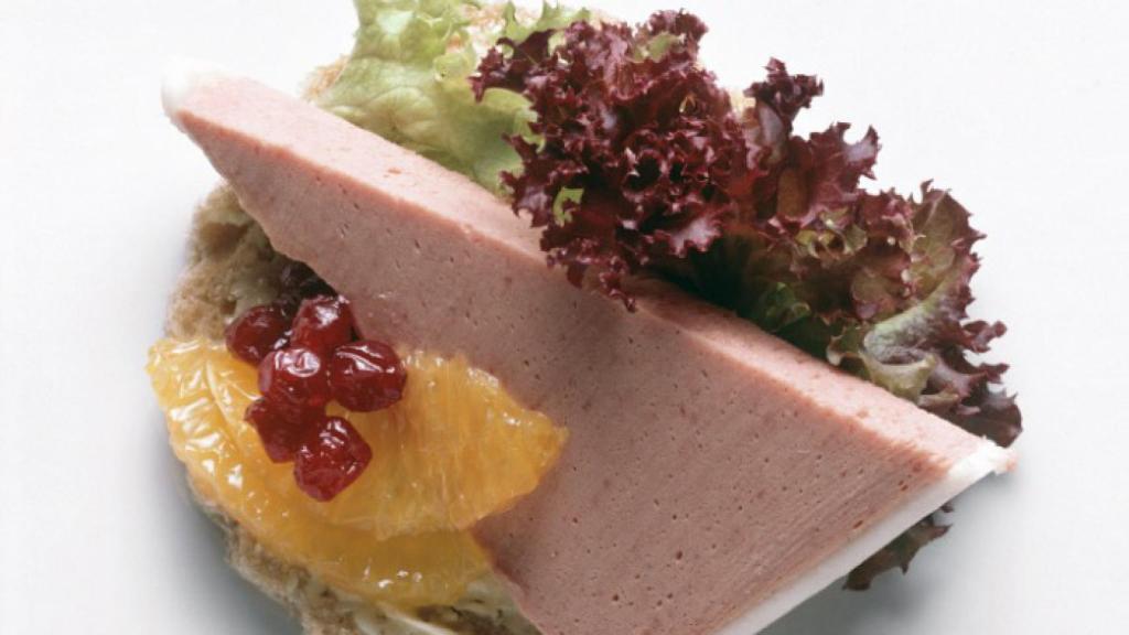 Un canapé con una porción de paté.