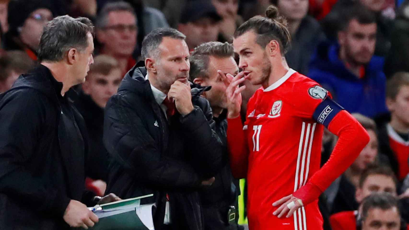 Ryan Giggs y Gareth Bale dialogan durante un partido de Gales
