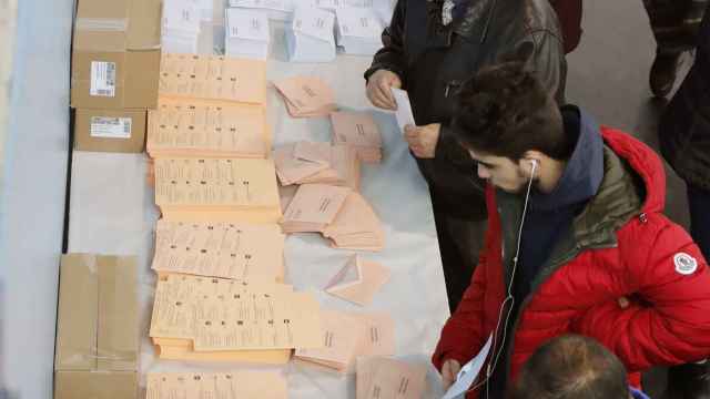 Un grupo de personas eligen sus papeletas en un colegio electoral en Santiago de Compostela.