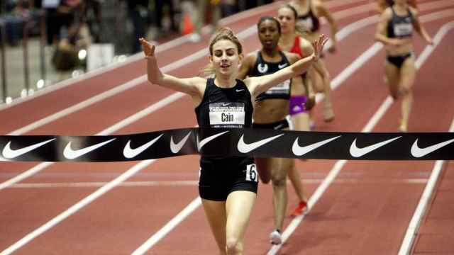 La atleta Mary Cain atraviesa una línea de meta con el logo de Nike.