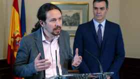 Pablo Iglesias explica los detalles del acuerdo de coalición, con Pedro Sánchez al fondo.