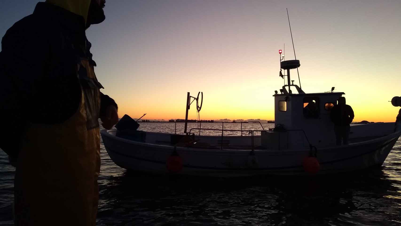 Manolo, patrón de la 'Begoñita', charlando  al amanecer con otros dos pescadores que han salido a faenar al Mar Menor porque se han quedado sin ayudas del Gobierno regional.