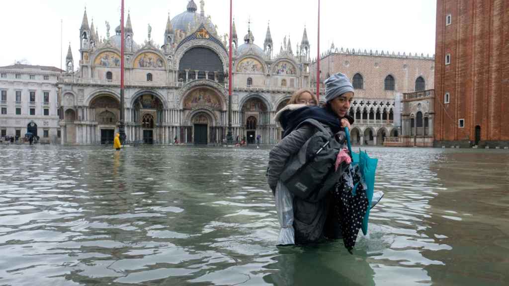 Una mujer y un niño tratan de avanzar por la inundada Plaza de San Marcos, en Venecia, este noviembre.