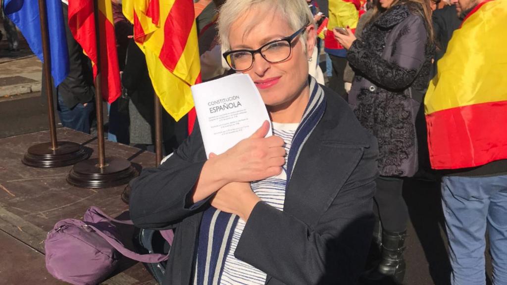 La periodista Anna Grau se abraza a un ejemplar bilingüe de la Constitución.