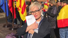 La periodista Anna Grau se abraza a un ejemplar bilingüe de la Constitución.
