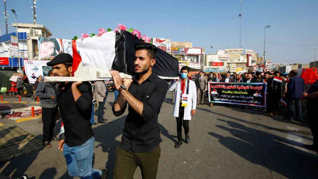 Manifestantes en Bagdad portan féretros de asesinados durante las propias marchas.