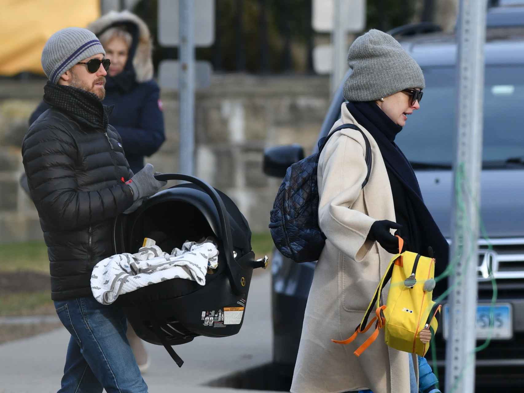 Anne Hathaway su marido paseando con un portabebés.