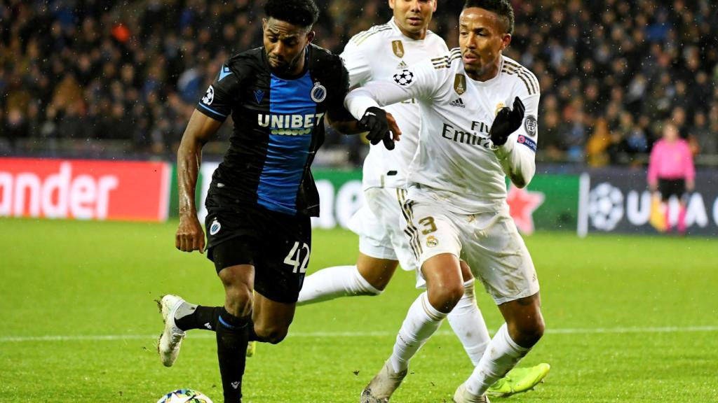 Militao presiona a Emmanuel Dennis