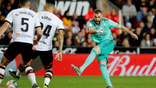 Karim Benzema disparando a portería con varios jugadores del Valencia delante