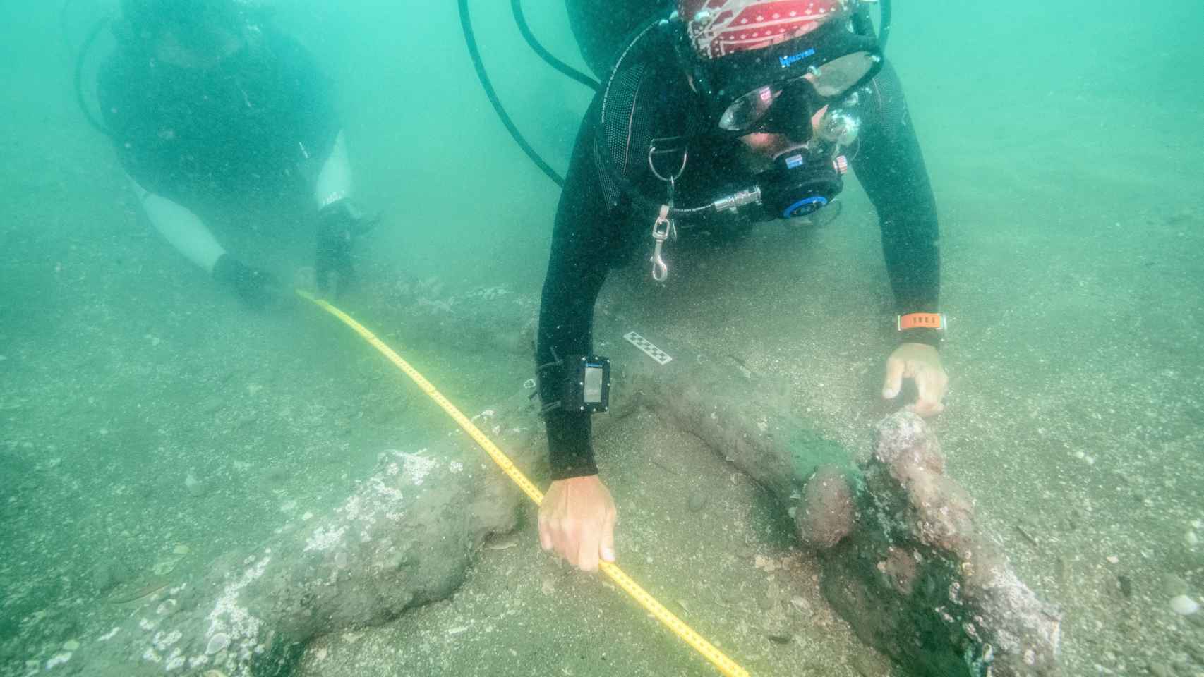 Uno de los arqueólogos submarinos con el ancla descubierta.
