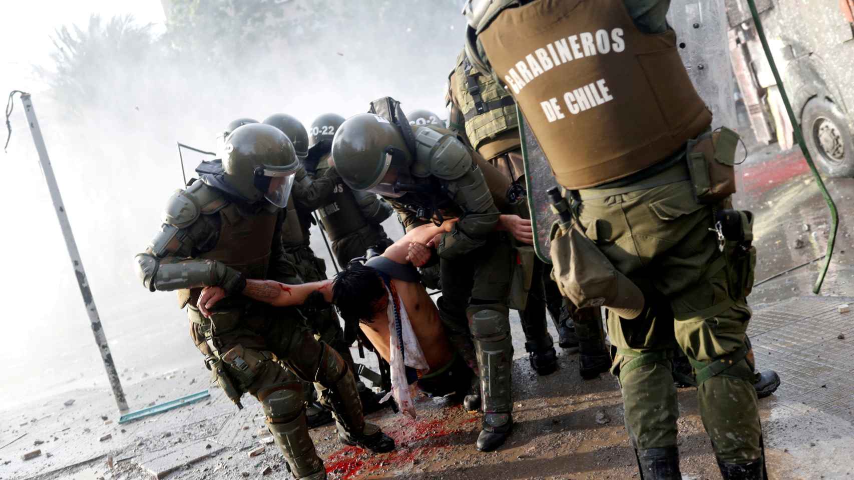 Un manifestante herido cargado por carabineros durante las protestas contra el gobierno chileno en Santiago, Chile.