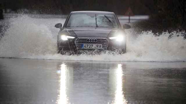 Un coche cruza la carretera LU-P-1701, en Muimenta, Lugo, inundada por el agua de los ríos Pequeño y Miño. EFE/ Eliseo Trigo
