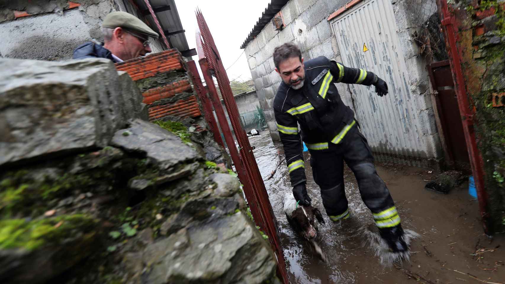 Un bombero ayuda a un perro en las calles inundadas de Ponferrada.