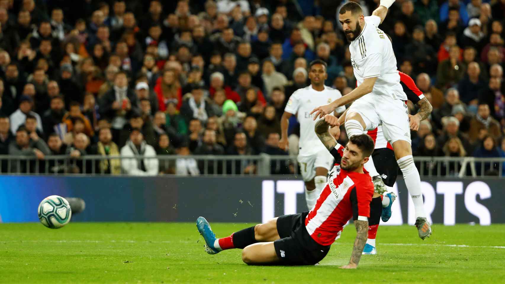Benzema dispara a puerta con un jugador del Athletic delante
