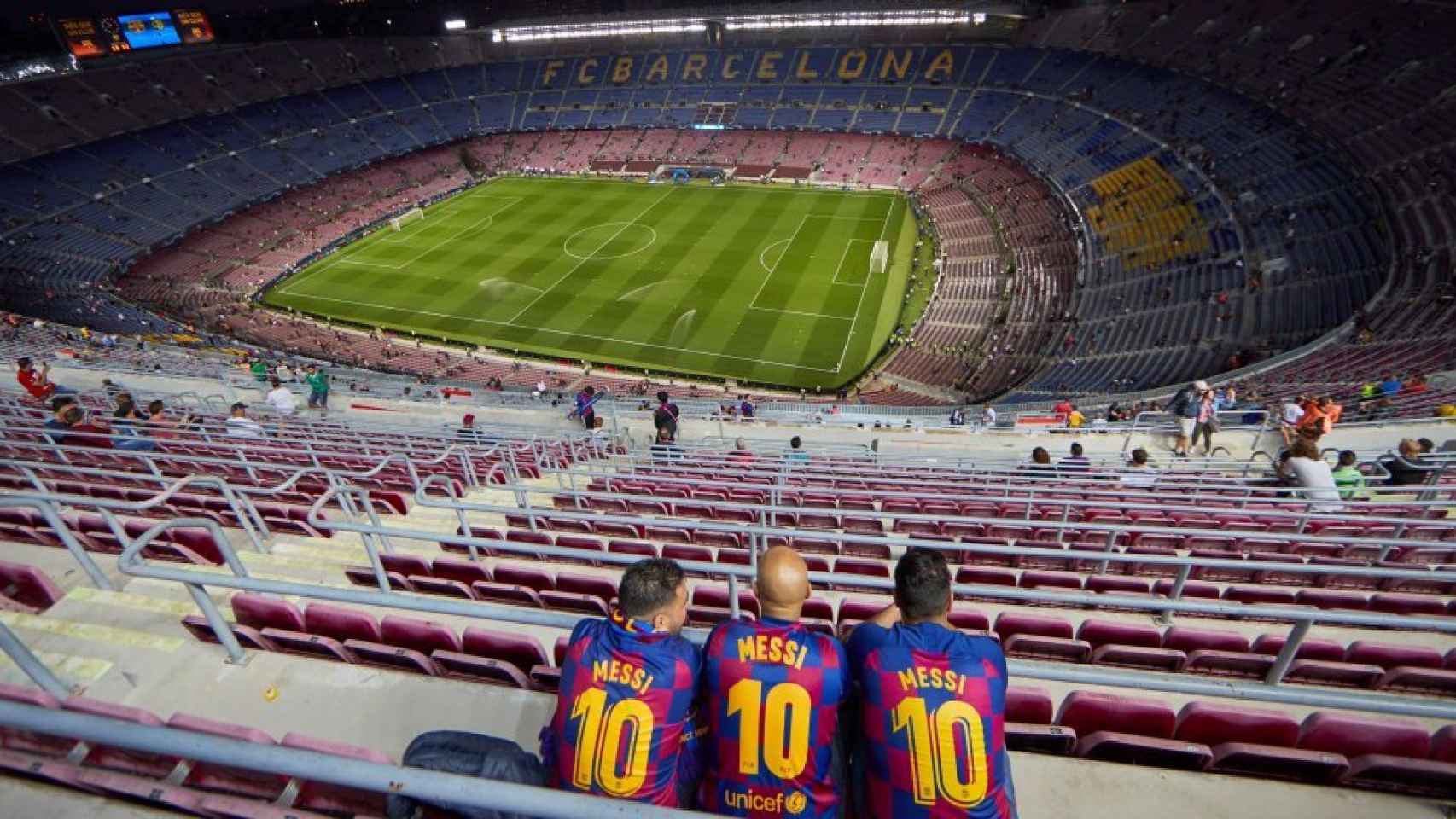 Tres aficionados en el Camp Nou vacío