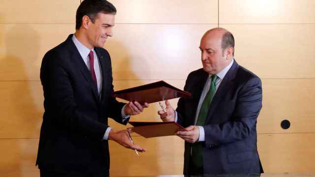 Pedro Sánchez y Andoni Ortuzar intercambian los documentos para la firma del acuerdo entre PSOE y PNV para la investidura.