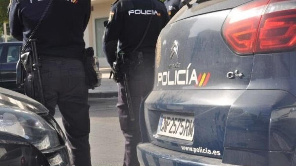 Agentes de la Policía Nacional, junto a sus coches.