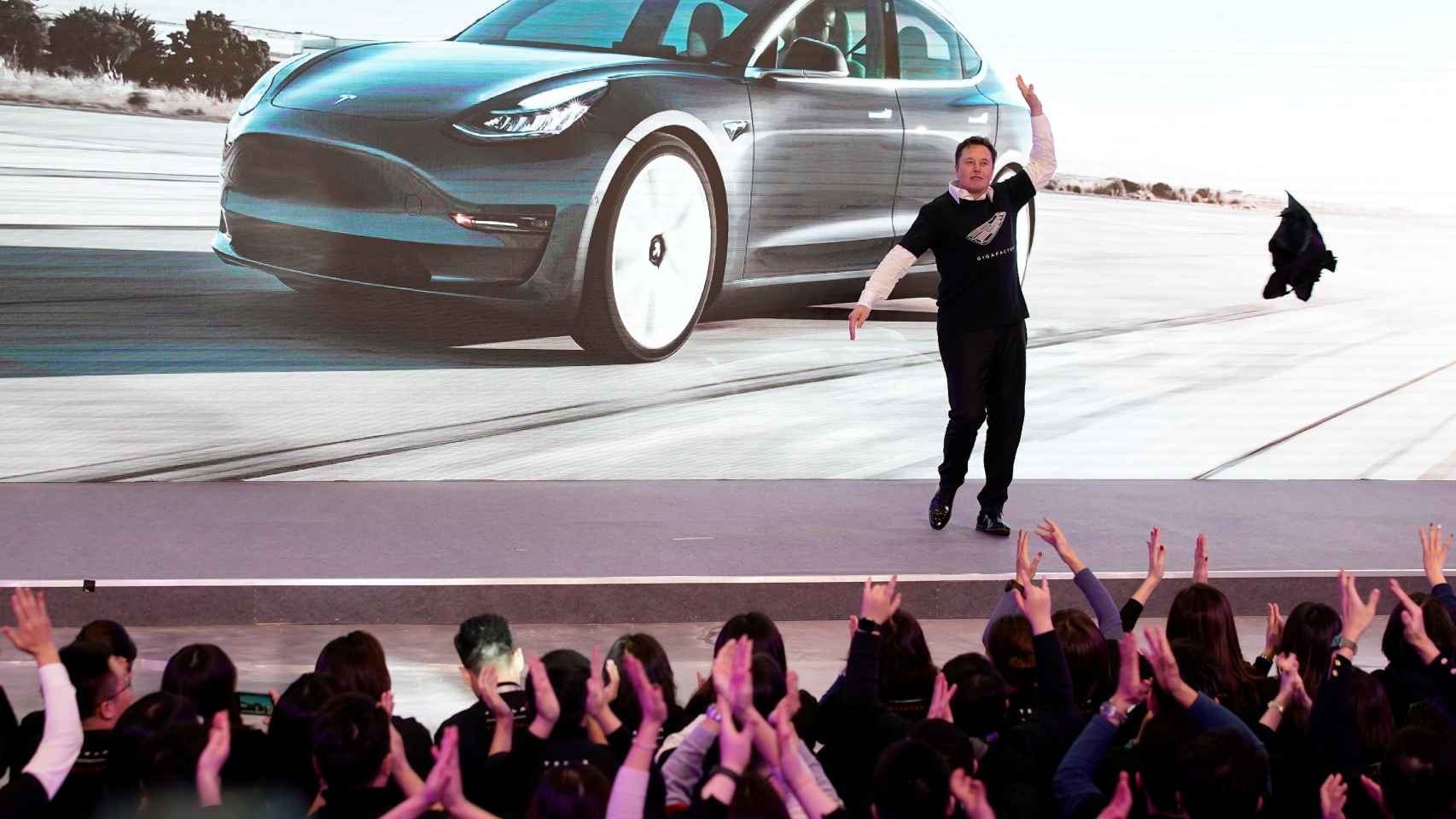 Tesla Inc CEO Elon Musk takes off his coat onstage during a delivery event for Tesla China-made Model 3 cars in Shanghai