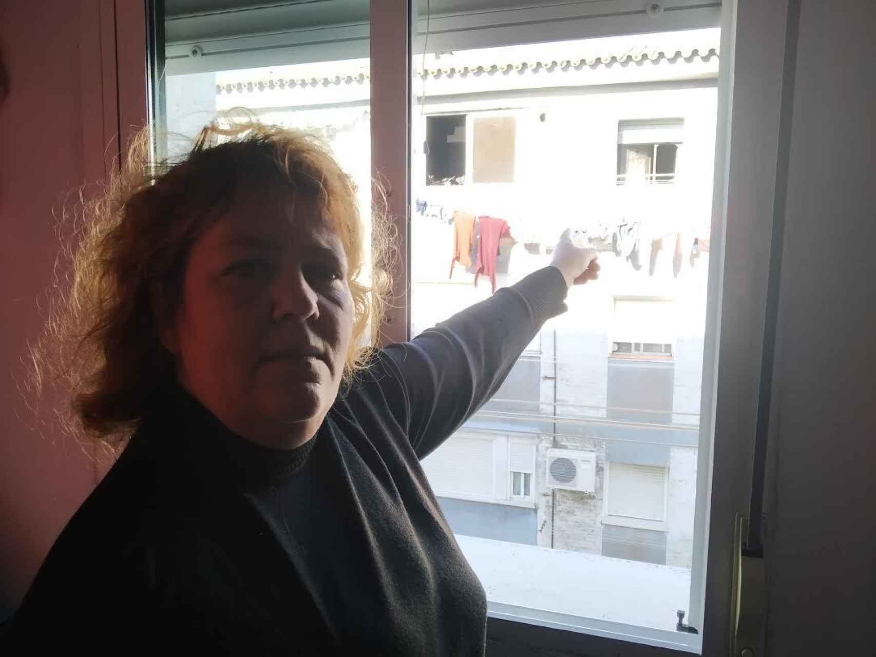María del Carmen Magro señala desde la ventana de su cocina el inmueble que sufrió el incendio.