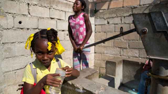 Dos niñas sacan agua de un pozo en Leogane (Haití)