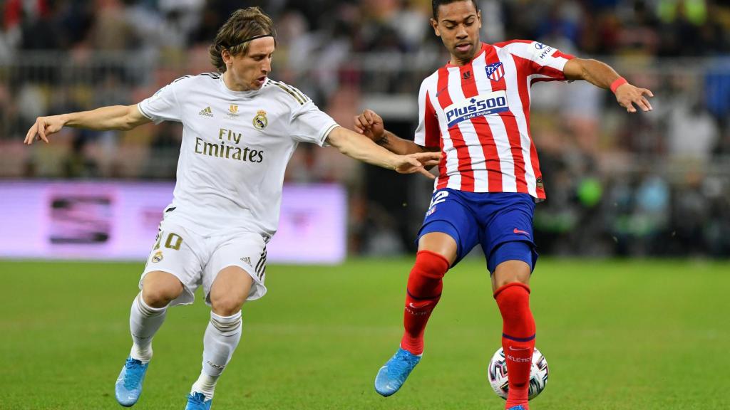 Luka Modric y Renan Lodi pelean por un balón