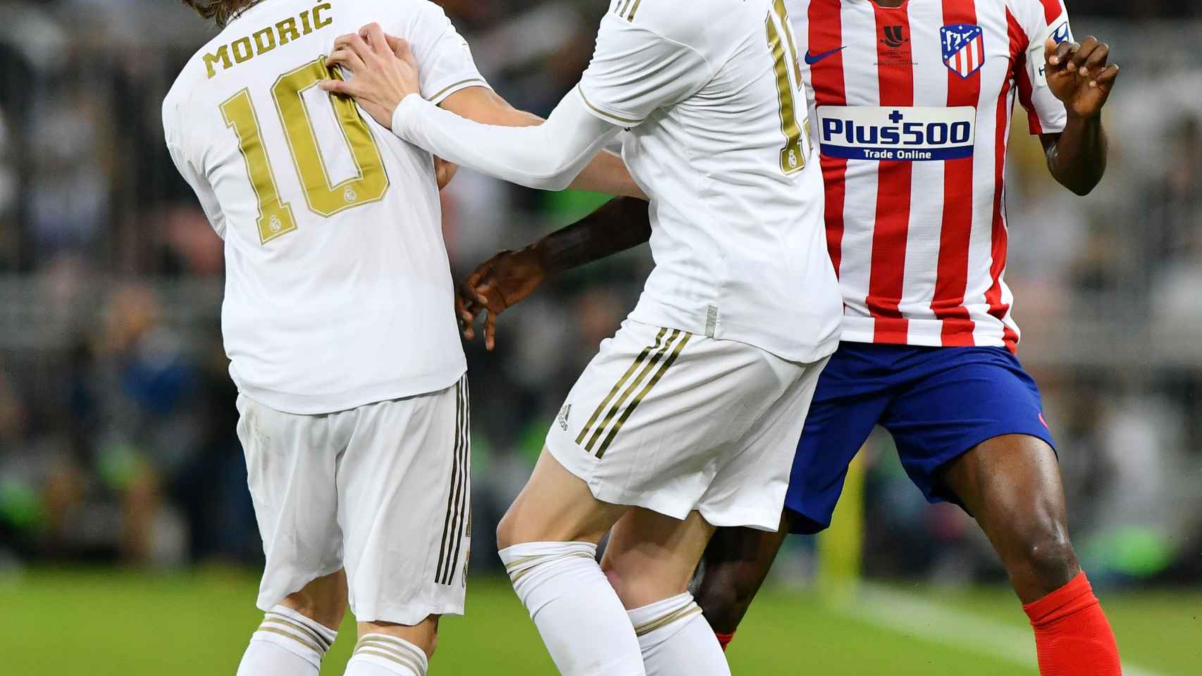 Fede Valverde intenta evitar el choque con Luka Modric mientras es presionado por Thomas Partey