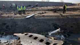 Miembros de los servicios de emergencia observan parte del fuselaje del Boeing 737 de la compañía ucraniana UIA que se estrelló en Teherán