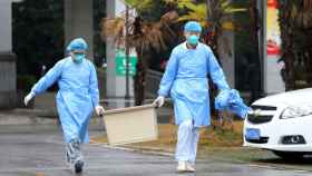 Personal médico de un hospital chino trasladando una caja con cepas del coronavirus de Wuhan.