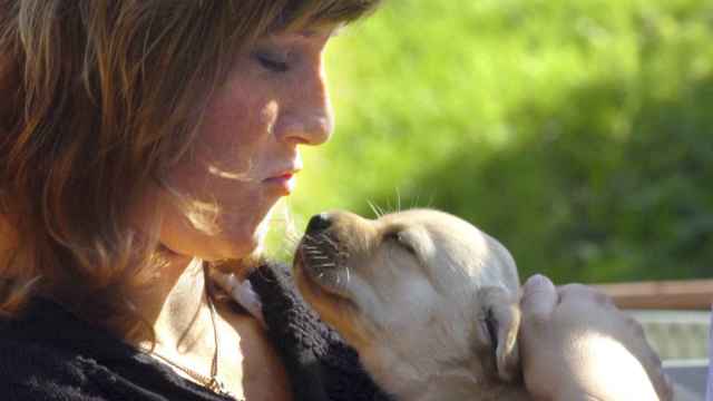 Marta Luisa de Noruega con un cachorro de perro guía en brazos.