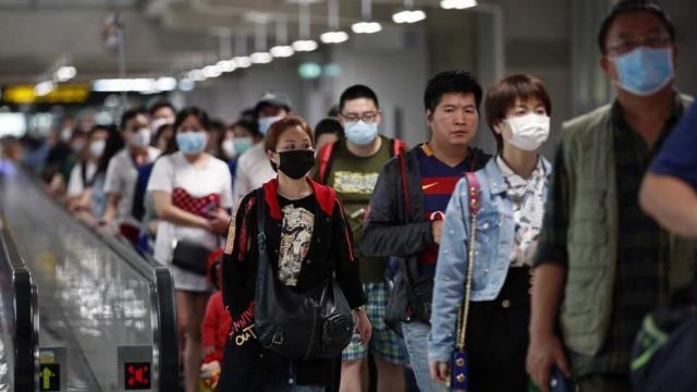 Un grupo de pasajeros en un aeropuerto asiático.