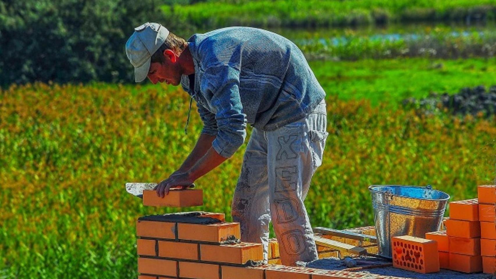 Un obrero trabajando con ladrillos.