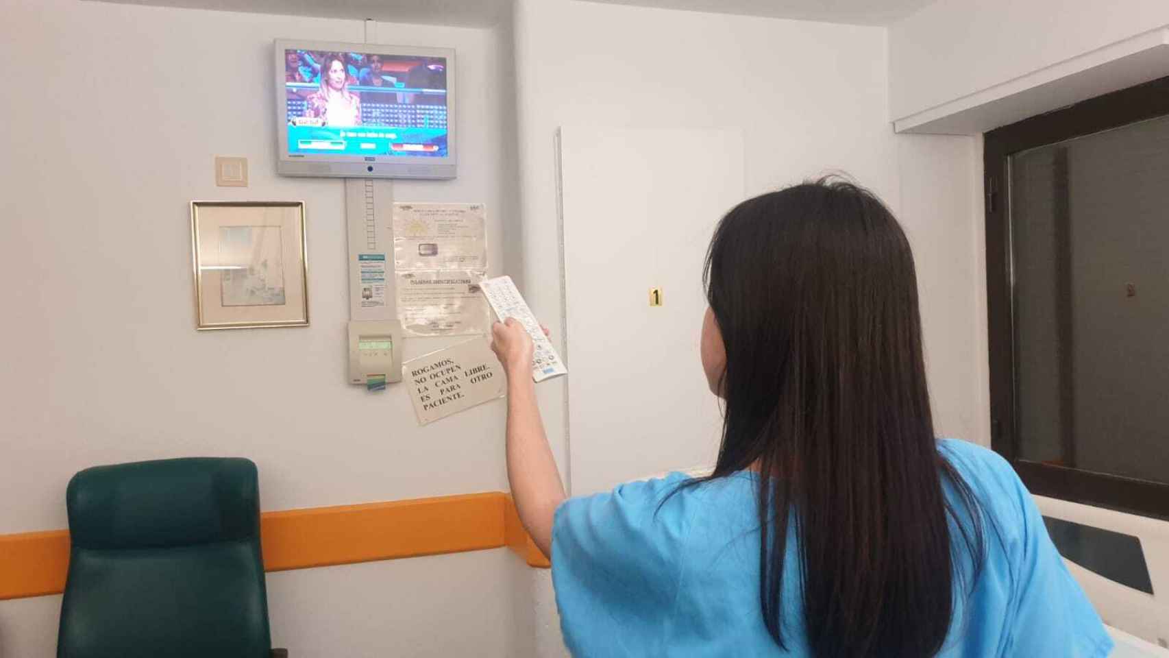 Una paciente utiliza la televisión de pago en un hospital público.