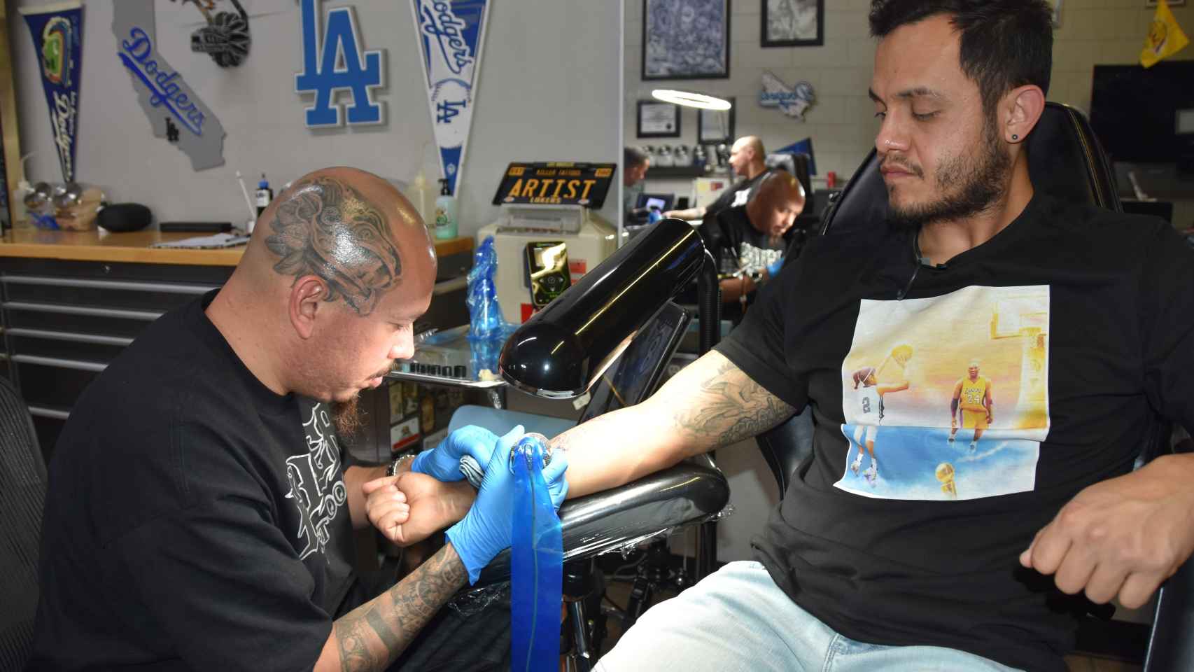 El artista José Rodríguez trabajando en un tatuaje sobre Kobe Bryant