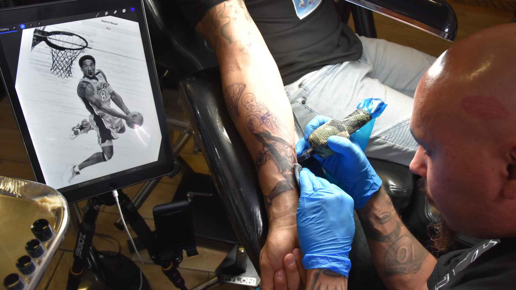 El tatuador José Guijosa creando una estampa de Kobe Bryant en la piel de un aficionado