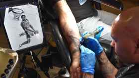 El tatuador José Guijosa creando una estampa de Kobe Bryant en la piel de un aficionado