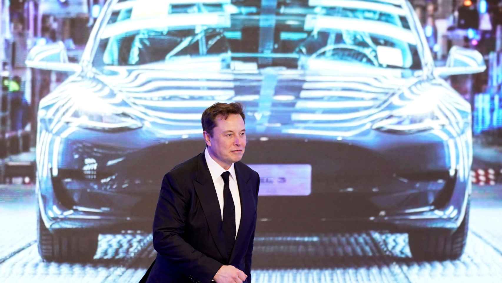 Elon Musk ante una foto de un Model 3.