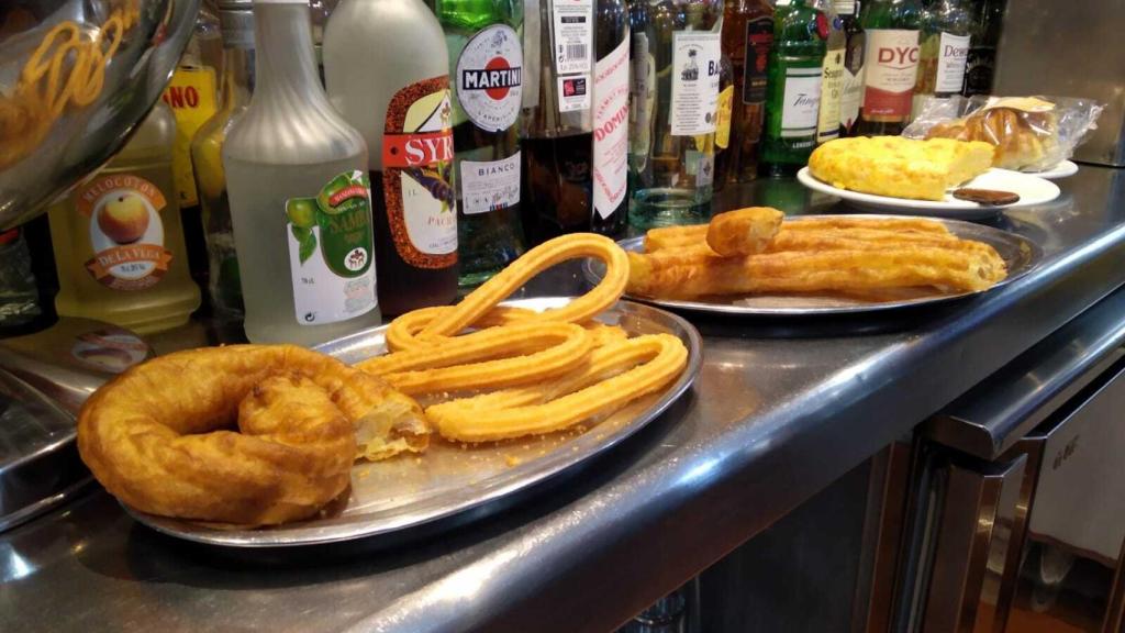 los churros y las porras, en dos bandejas, detrás de la barra.
