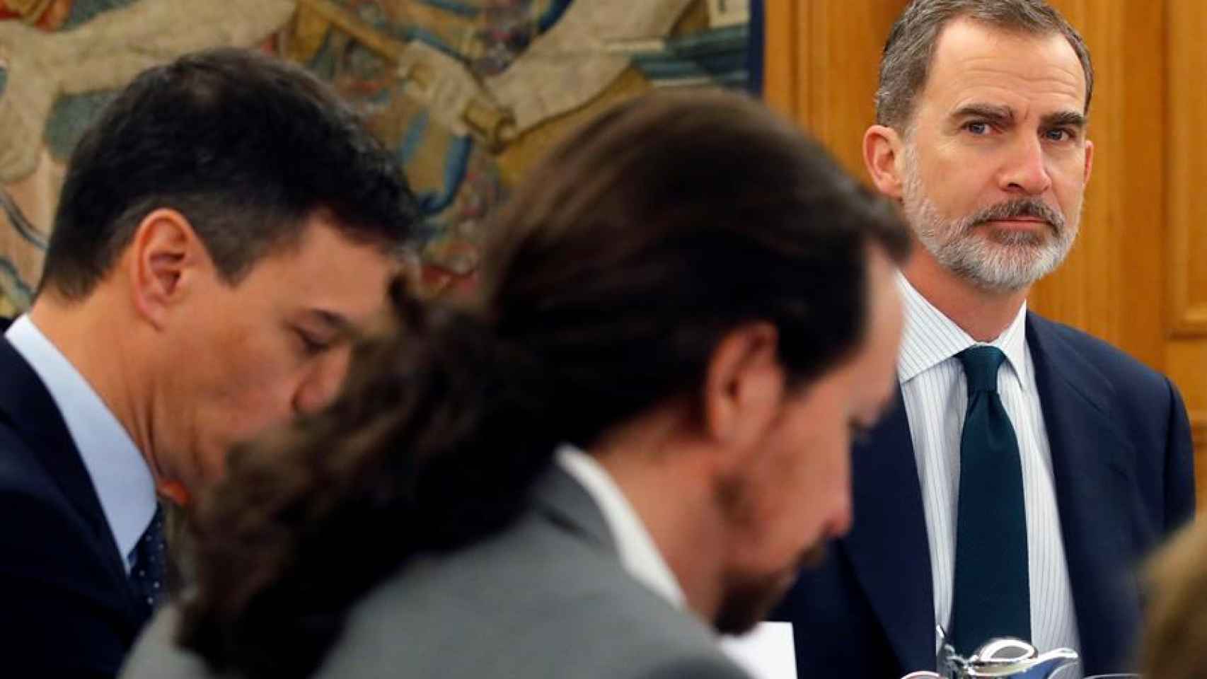 Pedro Sánchez mira atentamente a Pedro Sánchez y Pablo Iglesias durante la reunión de carácter informativo.