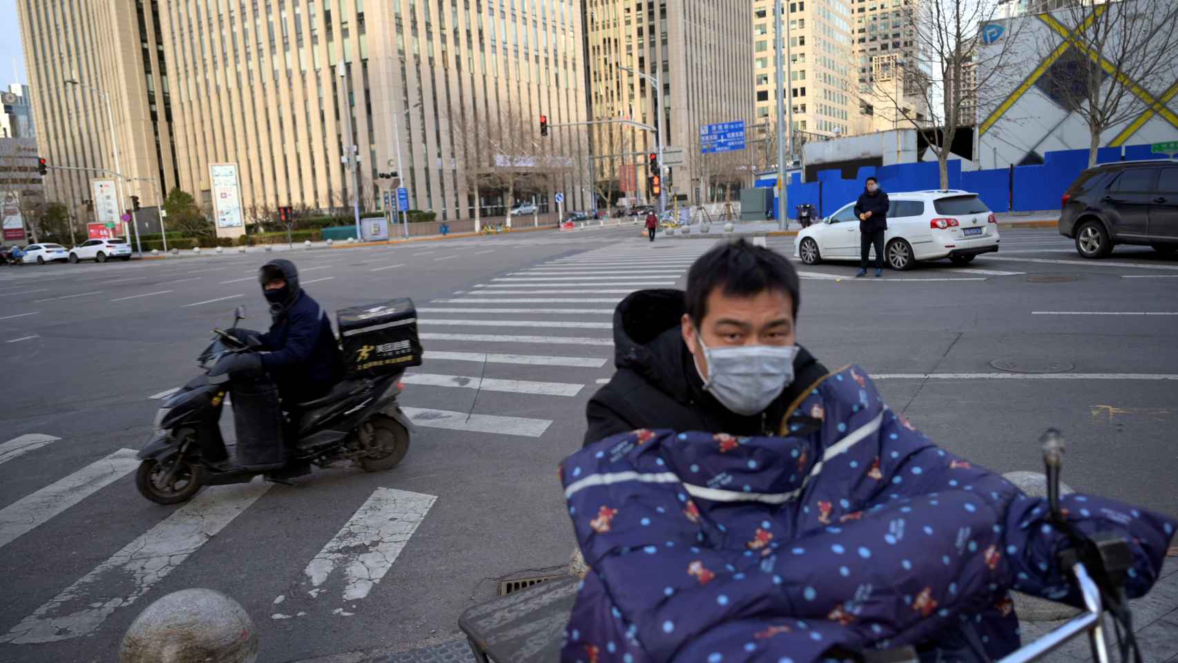 Moteros con mascarilla en las calles de Pekín