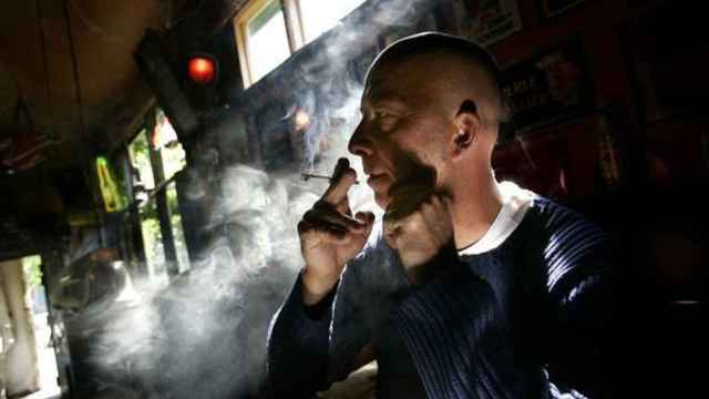 Un hombre fuma un cigarro de marihuana.