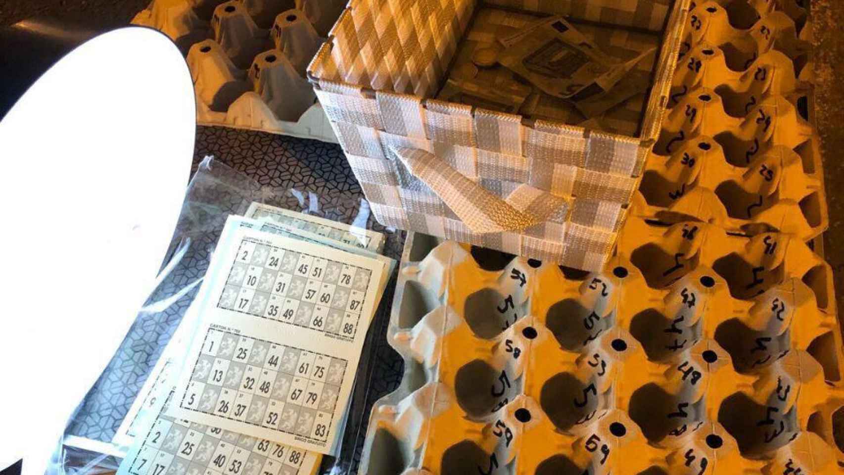 Una cesta con dinero y cajas de huevo para confeccionar un bingo.